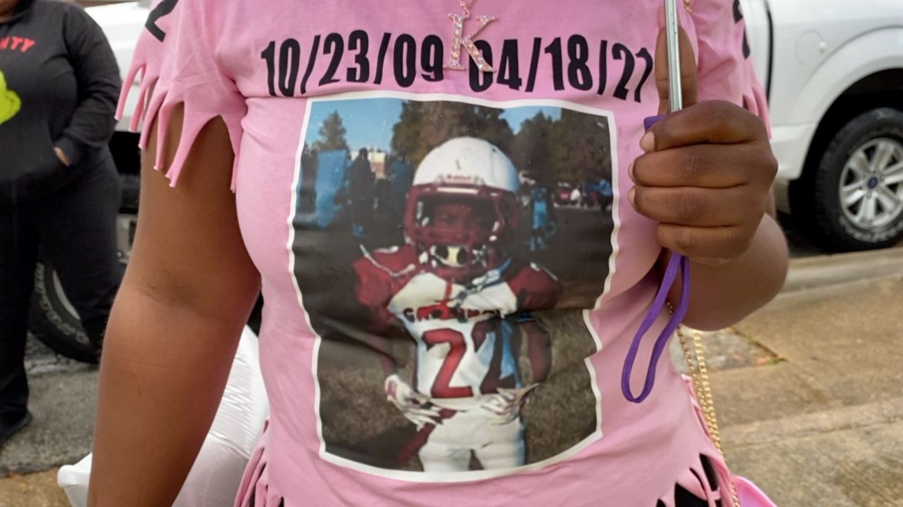 Pictured is 11-year-old Dazmon Ray Brown Jr. In his football uniform on the shirt worn by a family friend who attended a memorial service April 15 (Lupe Zapata/Spectrum News 1)